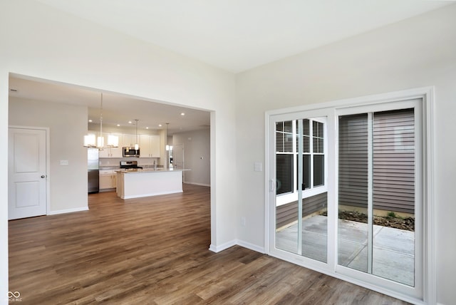 unfurnished living room with dark hardwood / wood-style flooring and an inviting chandelier