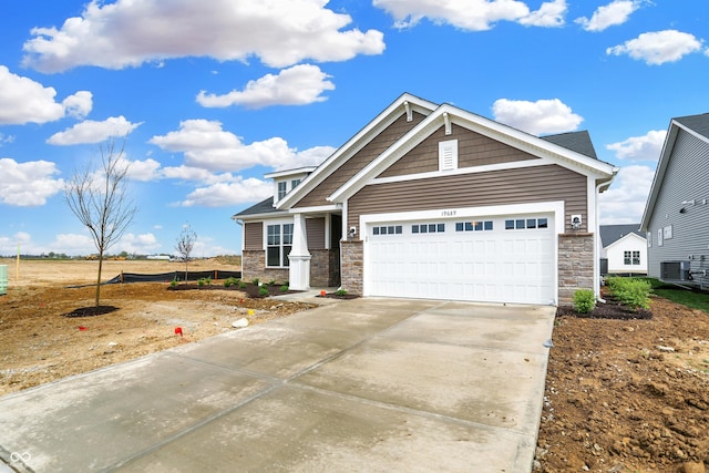 craftsman-style home featuring central air condition unit and a garage