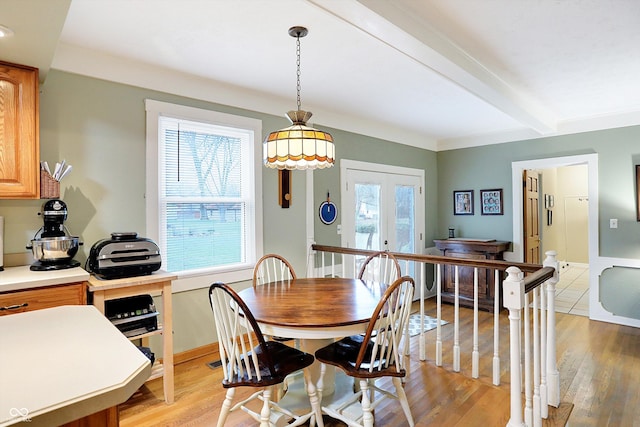 dining area with beamed ceiling, french doors, and light hardwood / wood-style floors