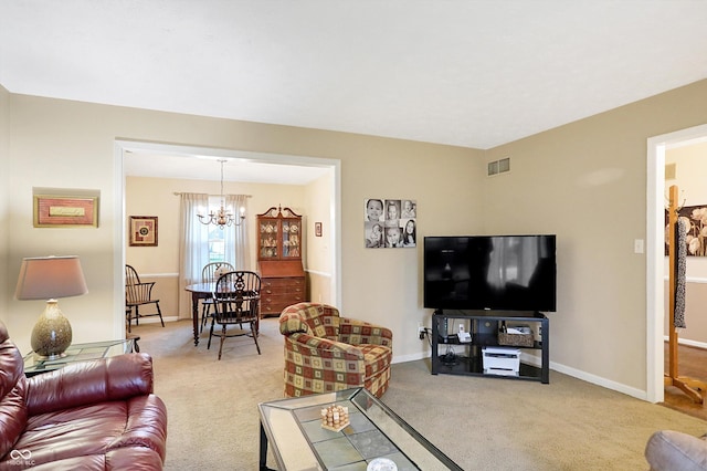 carpeted living room with a chandelier