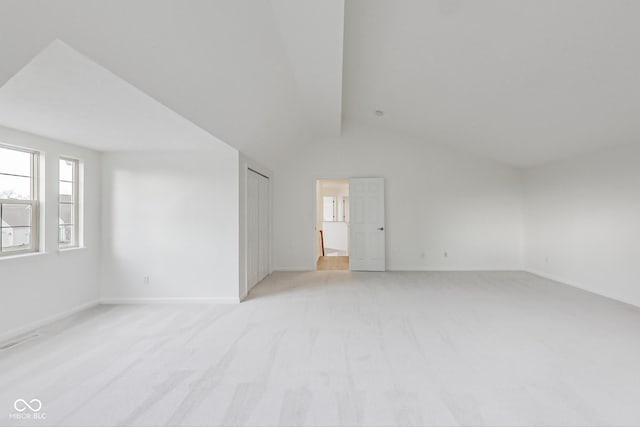 carpeted spare room featuring vaulted ceiling