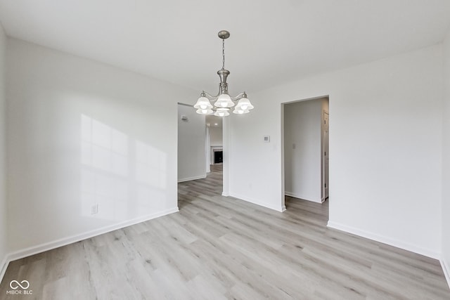 unfurnished dining area with a chandelier and light hardwood / wood-style flooring