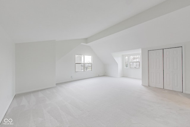 additional living space with a wealth of natural light, light colored carpet, and lofted ceiling