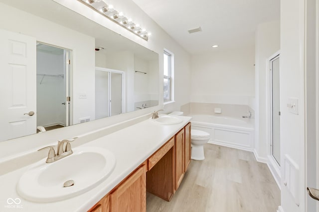 full bathroom with toilet, hardwood / wood-style floors, vanity, and shower with separate bathtub