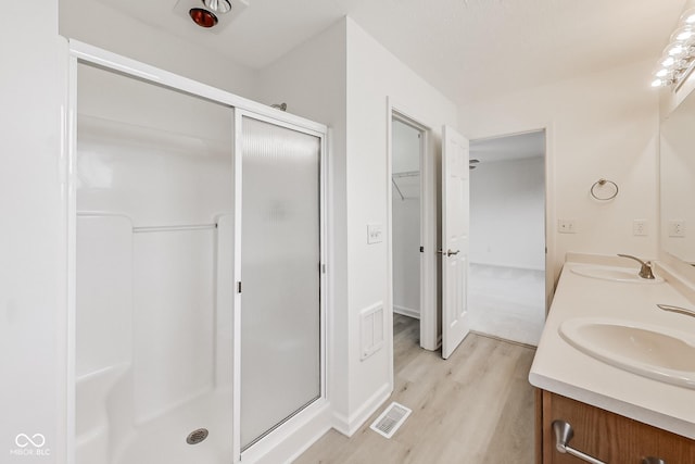 bathroom with vanity, wood-type flooring, and walk in shower