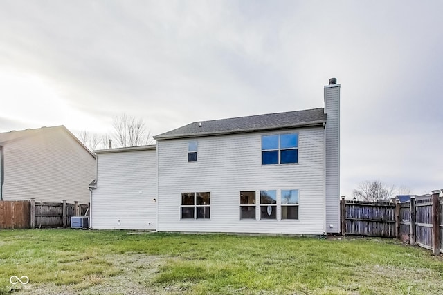 rear view of house with a lawn and central AC unit