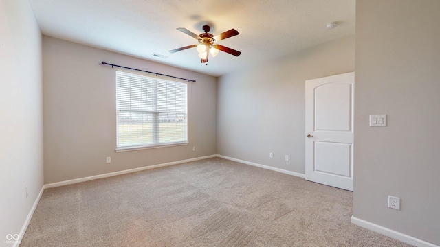 carpeted spare room with ceiling fan