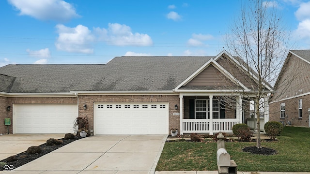 view of front of house with a front lawn, covered porch, and a garage