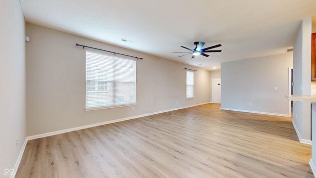 spare room with light hardwood / wood-style floors, ceiling fan, and a healthy amount of sunlight