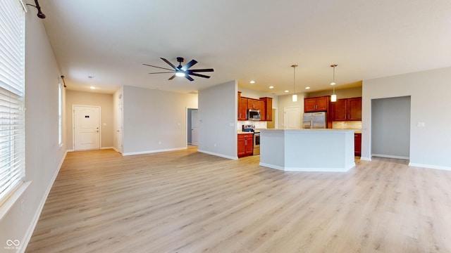 kitchen with pendant lighting, a kitchen island with sink, light hardwood / wood-style flooring, ceiling fan, and appliances with stainless steel finishes