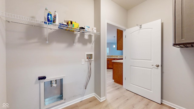 laundry room with hookup for a washing machine and light hardwood / wood-style floors