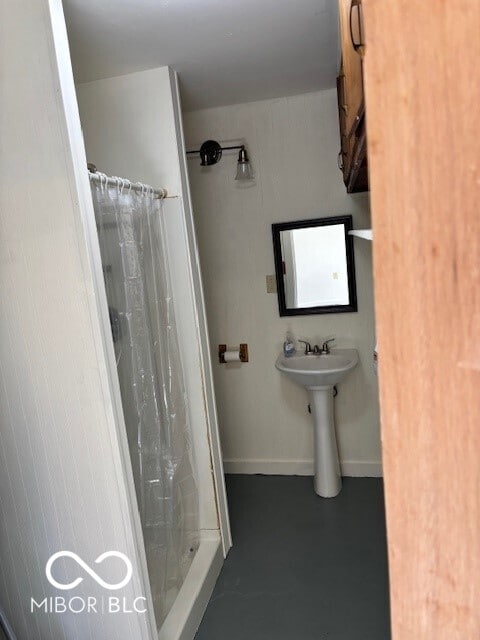 bathroom featuring a shower with shower curtain and concrete flooring