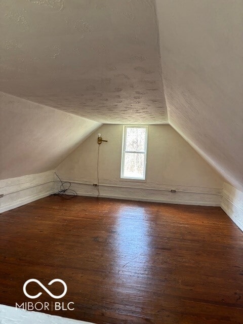 bonus room featuring dark hardwood / wood-style flooring and vaulted ceiling