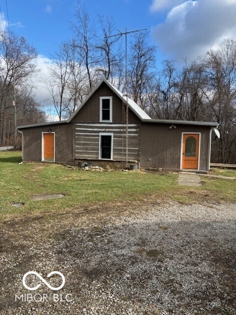 back of property featuring a lawn