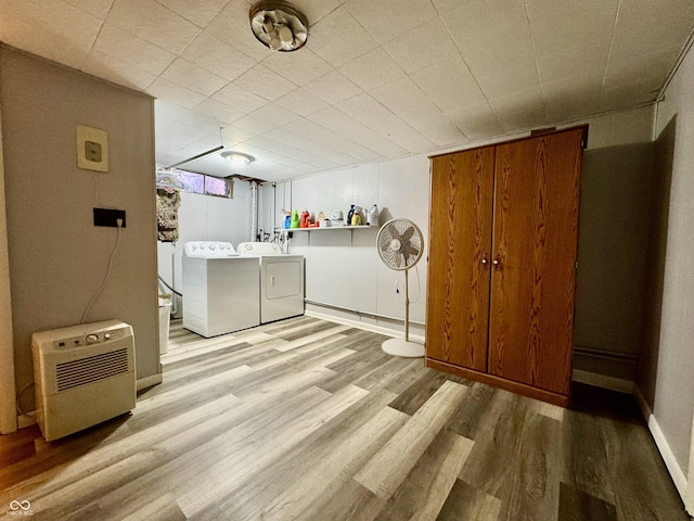 laundry room with washing machine and clothes dryer and light hardwood / wood-style flooring