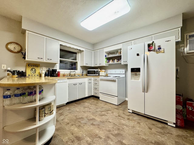 kitchen with white cabinets, a textured ceiling, white appliances, and sink