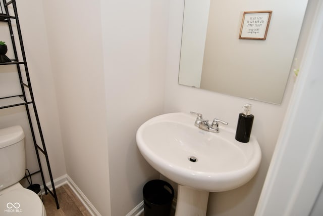 bathroom featuring sink, wood-type flooring, and toilet