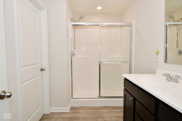 bathroom with vanity, an enclosed shower, and wood-type flooring