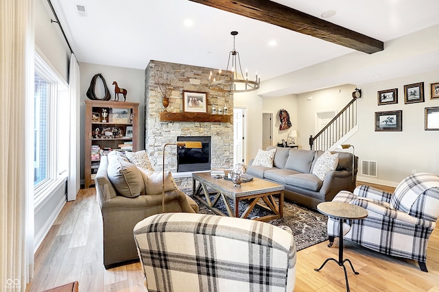 3441 S Overlook Pass, New Palestine, IN 46163 - living area with a stone fireplace, light wood finished floors, stairs, beamed ceiling, and a chandelier