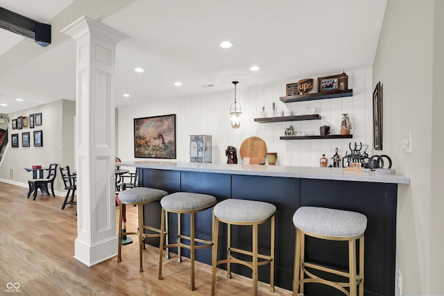 3441 S Overlook Pass, New Palestine, IN 46163 - indoor wet bar featuring decorative columns, stainless steel refrigerator, light wood-style flooring, recessed lighting, and hanging light fixtures