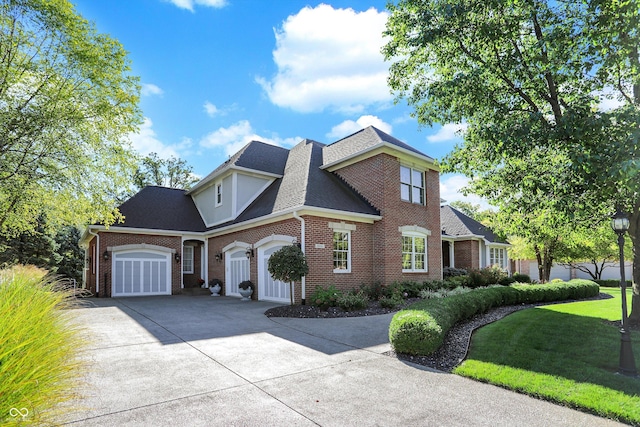 3441 S Overlook Pass, New Palestine, IN 46163 - view of front of house featuring an attached garage, brick siding, driveway, a front lawn, and a shingled roof