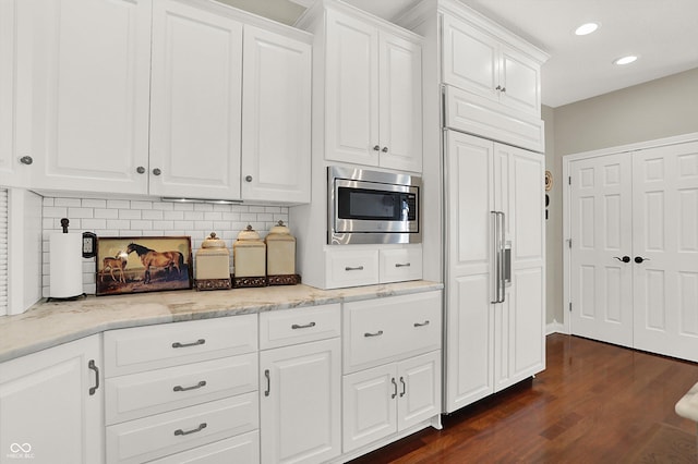 3441 S Overlook Pass, New Palestine, IN 46163 - kitchen featuring built in appliances, dark wood-type flooring, tasteful backsplash, white cabinetry, and recessed lighting