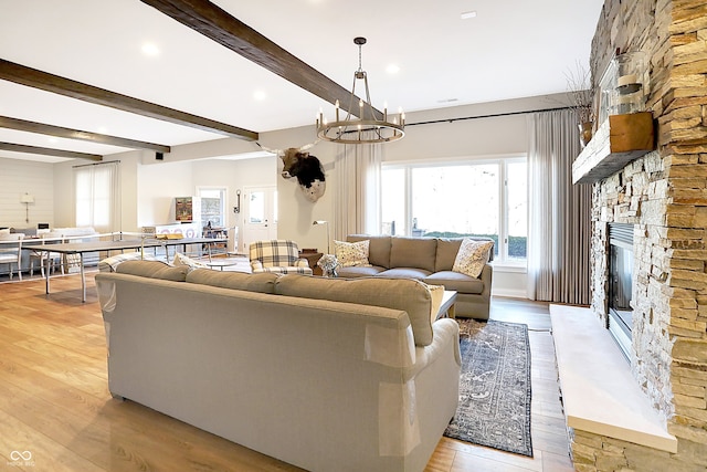 3441 S Overlook Pass, New Palestine, IN 46163 - living area with a stone fireplace, light wood-style floors, beam ceiling, a chandelier, and recessed lighting