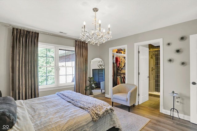3441 S Overlook Pass, New Palestine, IN 46163 - bedroom with a chandelier, a spacious closet, wood finished floors, a closet, and connected bathroom
