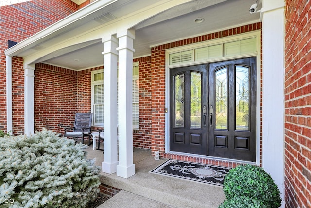 3441 S Overlook Pass, New Palestine, IN 46163 - property entrance with brick siding, a porch, and a surveillance system
