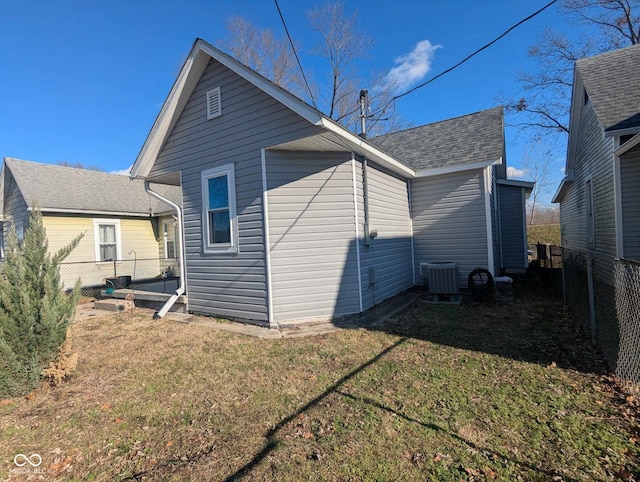 back of property featuring a lawn and cooling unit