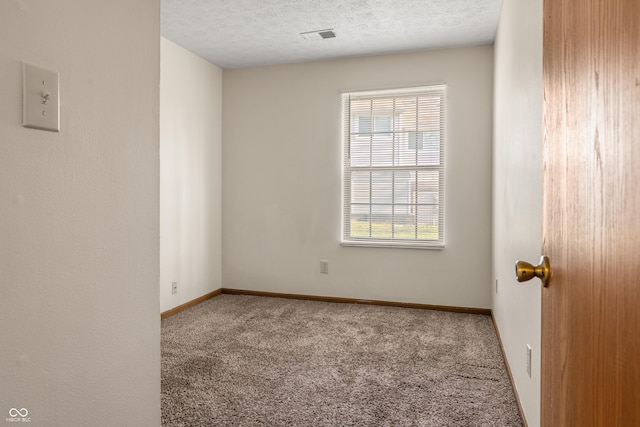 carpeted empty room featuring a textured ceiling