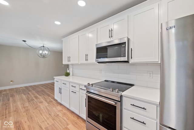 kitchen with backsplash, an inviting chandelier, light hardwood / wood-style floors, white cabinetry, and stainless steel appliances