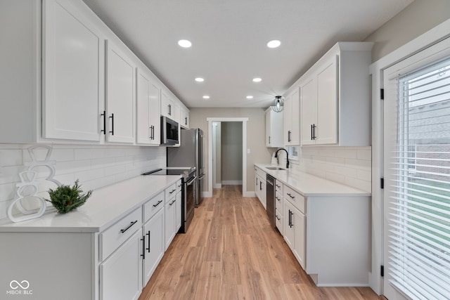 kitchen featuring white cabinetry, stainless steel appliances, and light hardwood / wood-style flooring