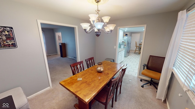 dining area with a chandelier and light colored carpet