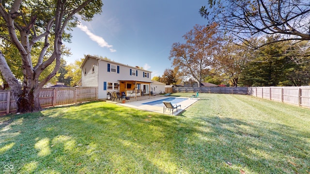 back of property with a fenced in pool, a patio area, and a lawn