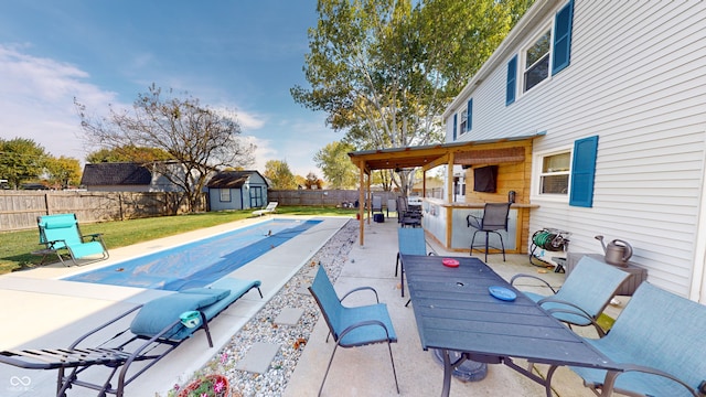 view of swimming pool with a storage unit, exterior bar, and a patio