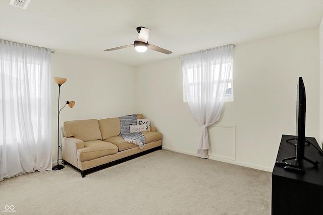 living room with ceiling fan, light colored carpet, and a wealth of natural light