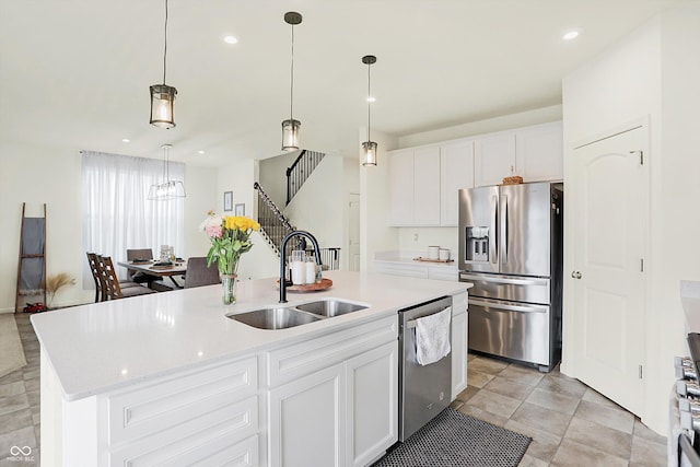 kitchen with white cabinetry, sink, decorative light fixtures, a center island with sink, and appliances with stainless steel finishes