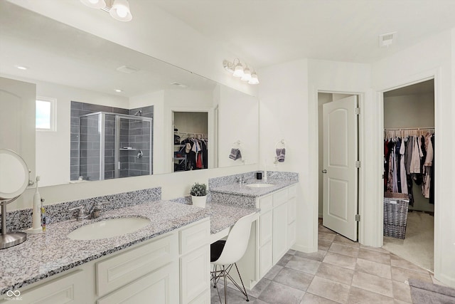 bathroom featuring a shower with door, vanity, and tile patterned flooring