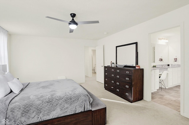 bedroom with ceiling fan, ensuite bathroom, and light carpet