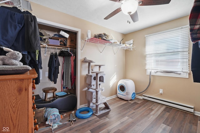 interior space featuring hardwood / wood-style floors, a textured ceiling, baseboard heating, and ceiling fan