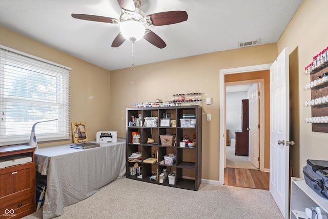 carpeted office featuring ceiling fan