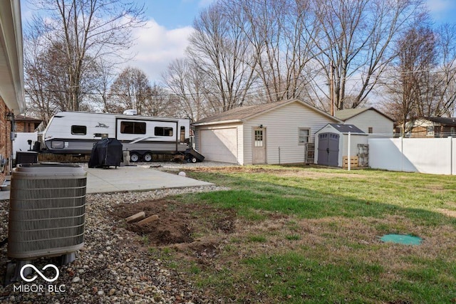 view of yard with a patio area, a shed, and central air condition unit