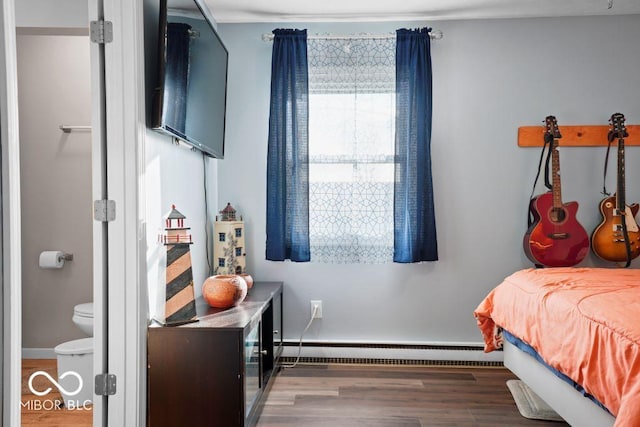 bedroom with dark hardwood / wood-style flooring and a baseboard radiator