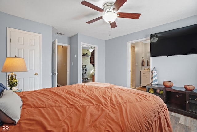 bedroom featuring ensuite bathroom, ceiling fan, and light wood-type flooring