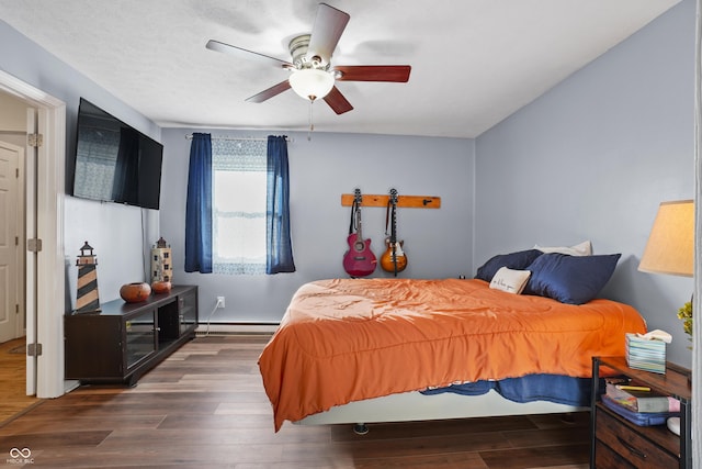 bedroom with ceiling fan, dark hardwood / wood-style flooring, and a baseboard radiator