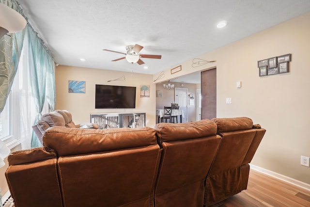 living room with ceiling fan and light hardwood / wood-style flooring