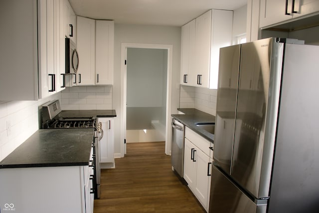 kitchen with sink, decorative backsplash, appliances with stainless steel finishes, dark hardwood / wood-style flooring, and white cabinetry