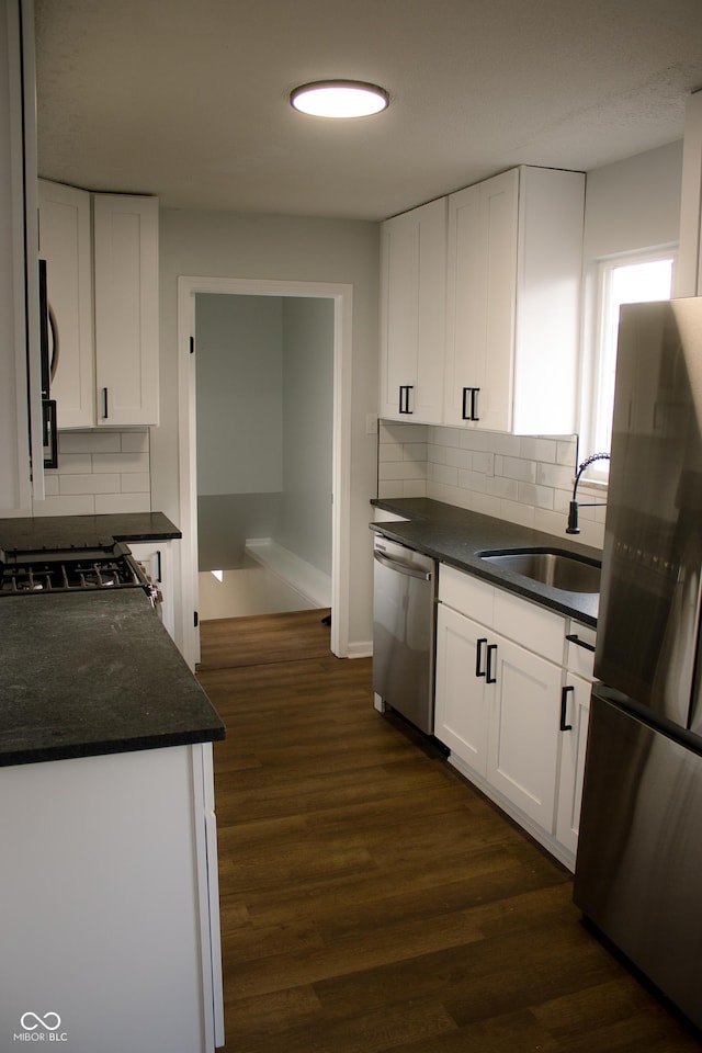 kitchen featuring sink, stainless steel appliances, dark hardwood / wood-style floors, backsplash, and white cabinets