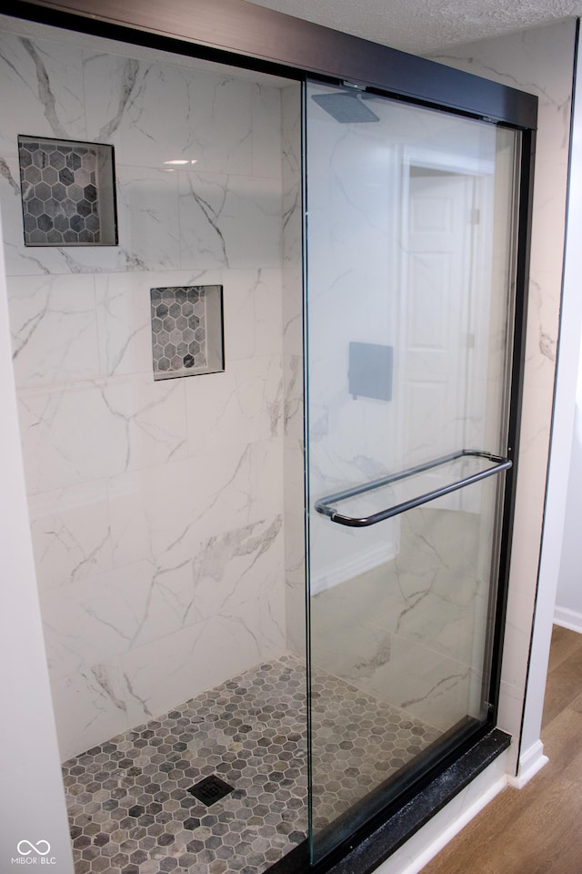 bathroom featuring an enclosed shower and wood-type flooring